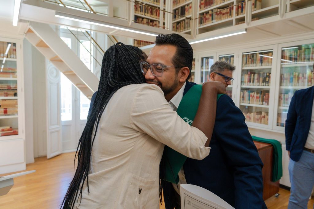 Abrazo de felicitación entre asistentes al acto